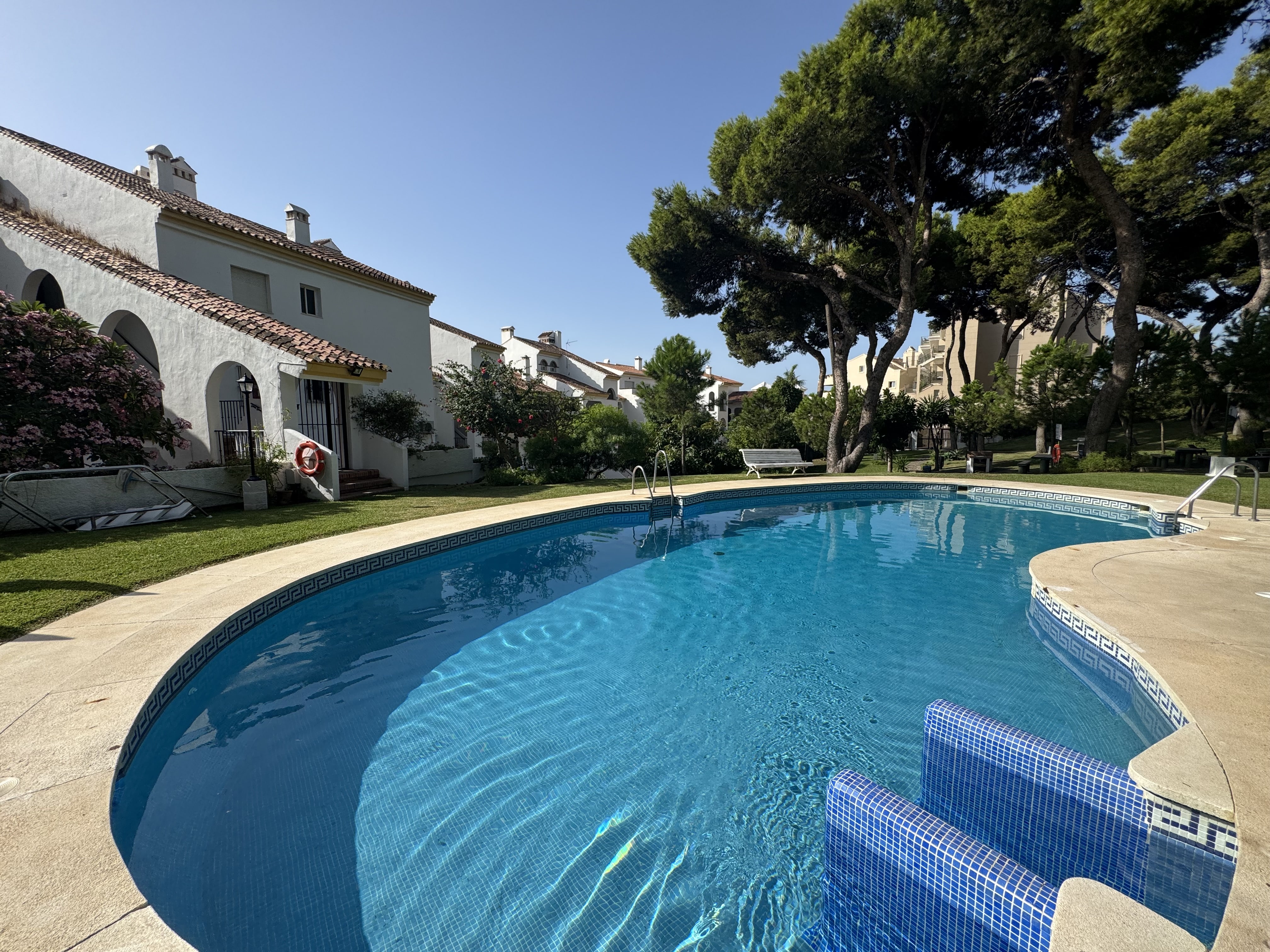 Piscina comunitaria rodeada de jardines en Benalmádena Costa