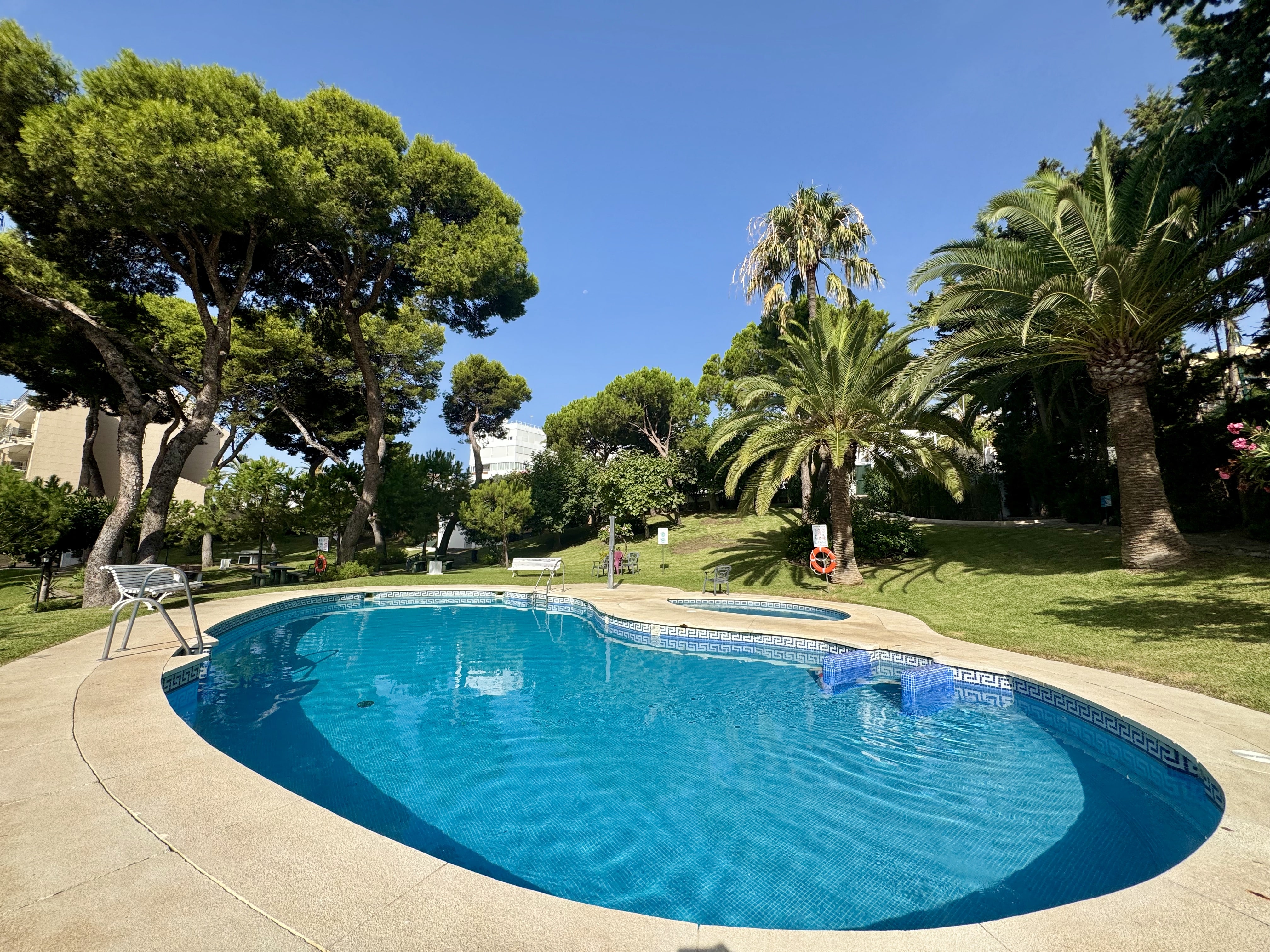 Piscina comunitaria rodeada de jardines en Benalmádena Costa